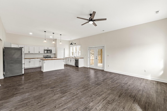 unfurnished living room with ceiling fan, visible vents, baseboards, french doors, and dark wood finished floors