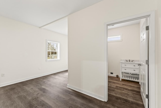 hall with baseboards and dark wood-type flooring