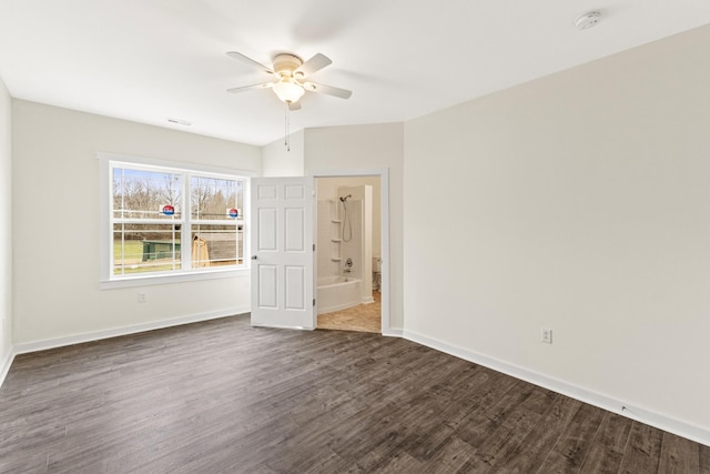 spare room featuring dark wood-style floors, visible vents, baseboards, and a ceiling fan