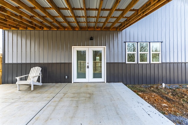 doorway to property with board and batten siding, french doors, and a patio