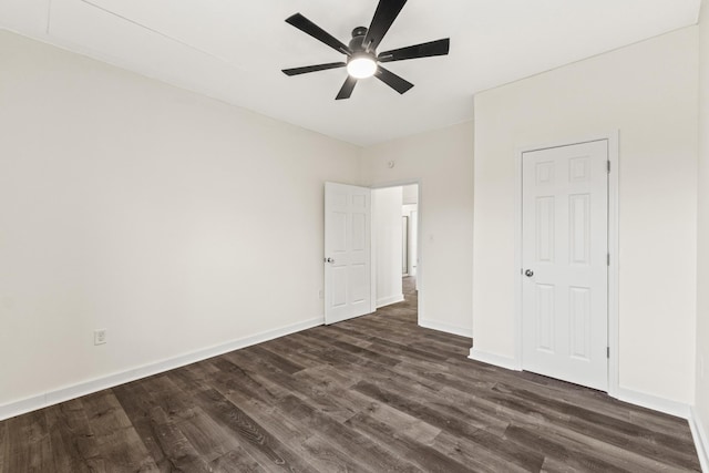 unfurnished bedroom featuring ceiling fan, dark wood-style flooring, and baseboards