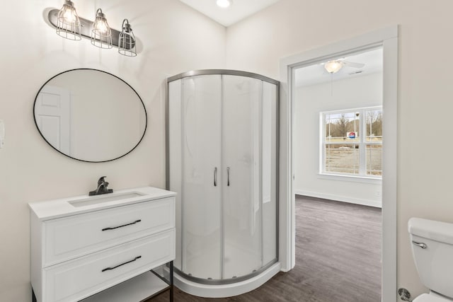 full bath with toilet, wood finished floors, a shower stall, and vanity