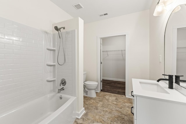 full bathroom with shower / bath combination, visible vents, toilet, a walk in closet, and vanity