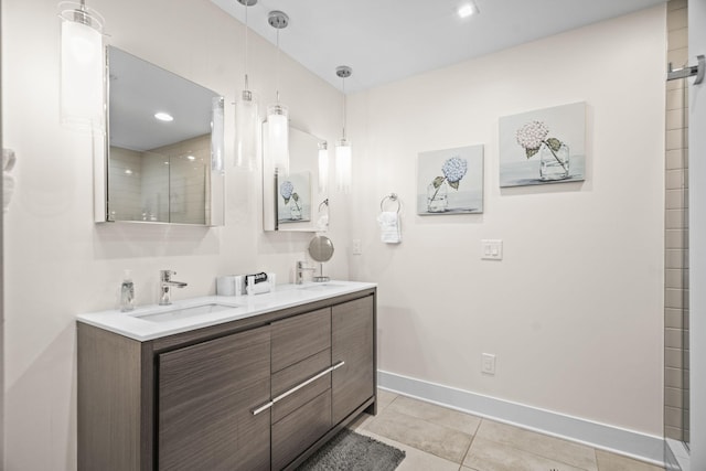 bathroom with baseboards, double vanity, a sink, and tile patterned floors