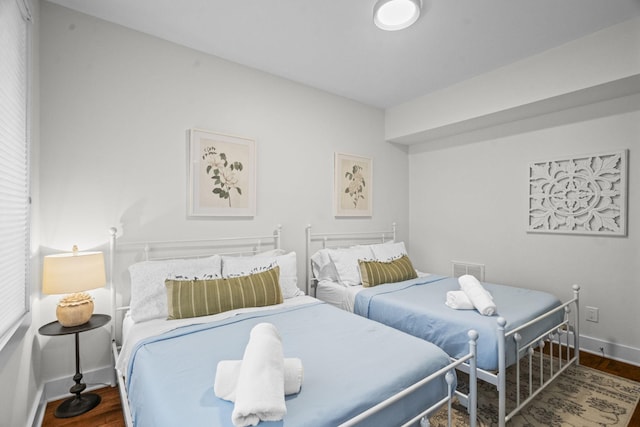 bedroom featuring visible vents, baseboards, and wood finished floors