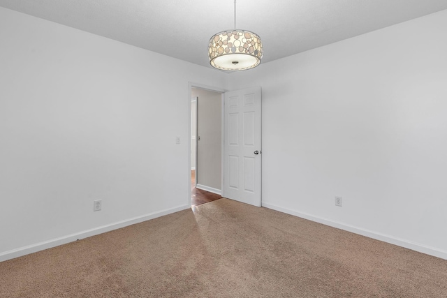 unfurnished room with carpet and baseboards