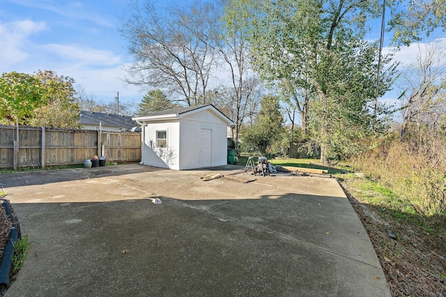 exterior space featuring a patio area, a fenced backyard, an outdoor structure, and a storage unit