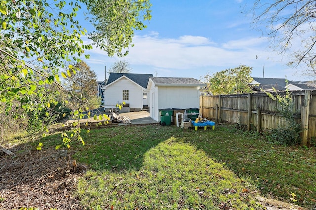 back of property with a fenced backyard, a lawn, and a patio