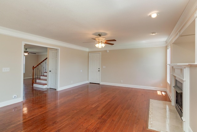 unfurnished living room featuring light wood-style flooring, a fireplace with flush hearth, baseboards, ornamental molding, and stairway