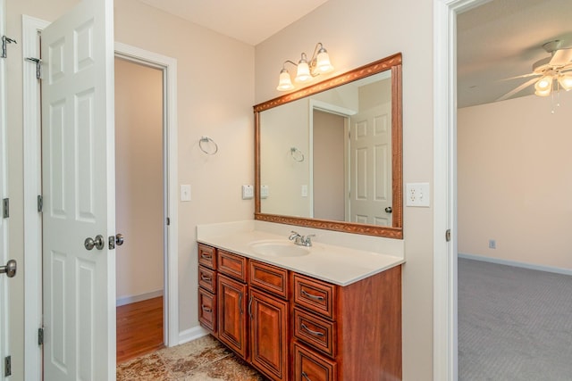 bathroom with a ceiling fan, vanity, and baseboards