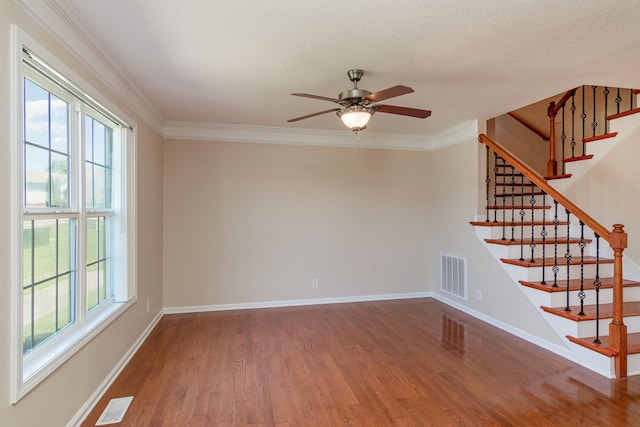 unfurnished room with a wealth of natural light, wood finished floors, and visible vents