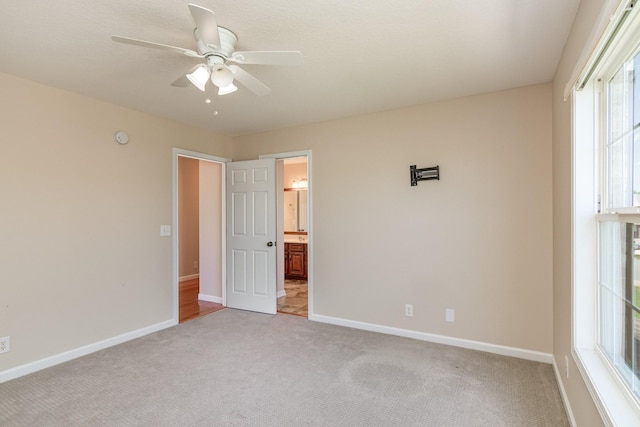 empty room with light carpet, ceiling fan, and baseboards