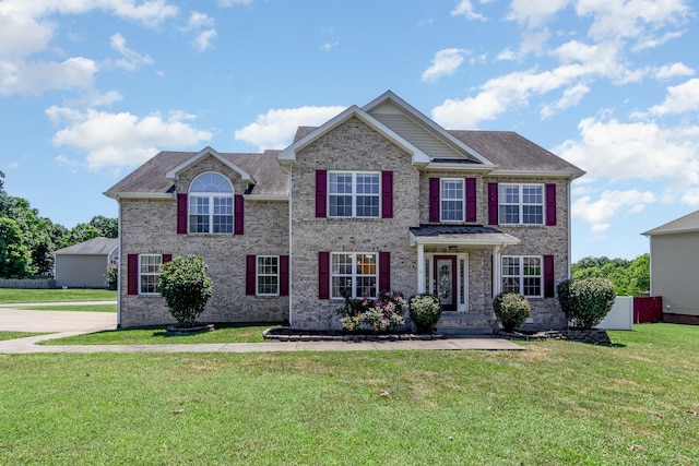 view of front of home with a front yard and brick siding