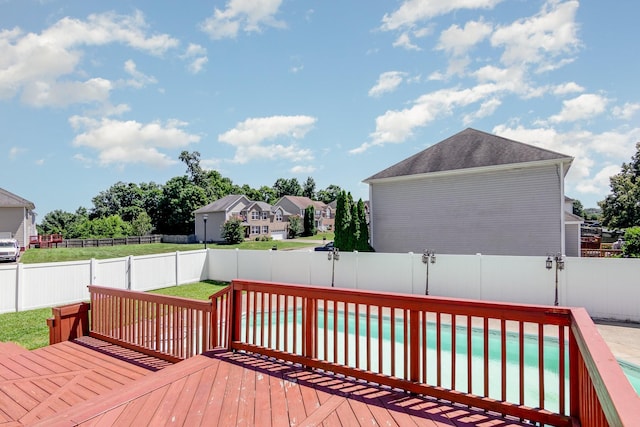 wooden deck with a lawn, a fenced backyard, and a fenced in pool