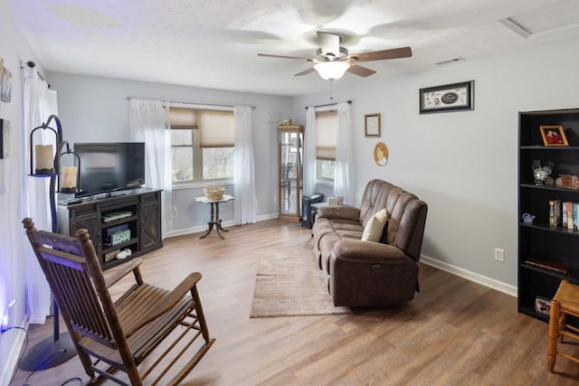 living room featuring a textured ceiling, wood finished floors, and baseboards