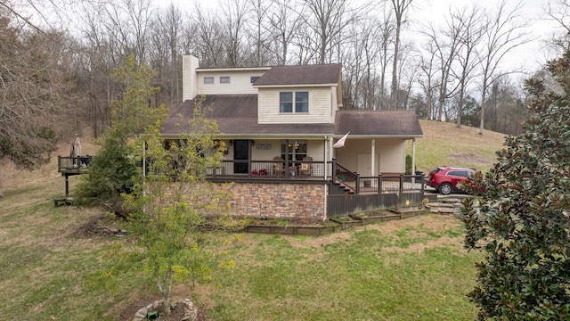 view of front facade with covered porch, a chimney, and a front lawn