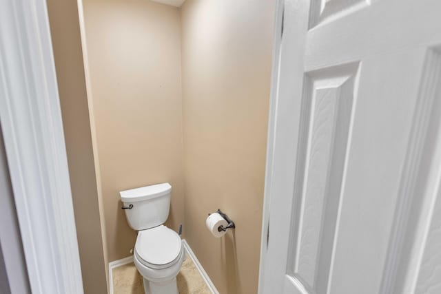 bathroom featuring baseboards, toilet, and tile patterned floors