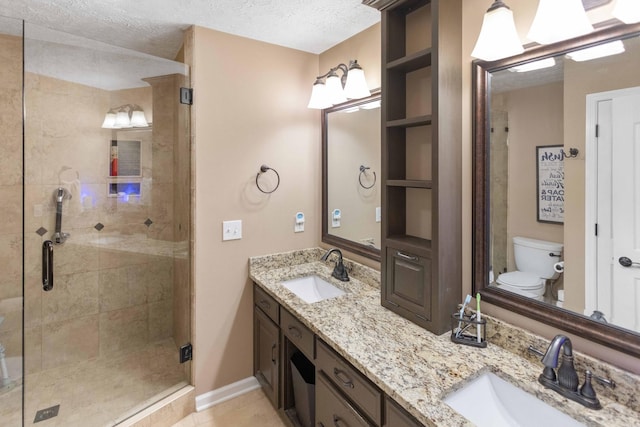 full bathroom with toilet, a shower stall, a textured ceiling, and a sink