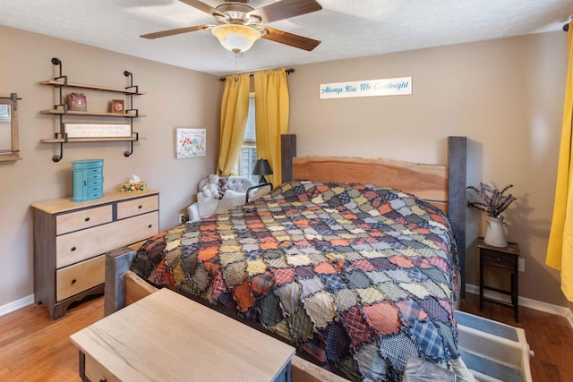 bedroom featuring ceiling fan, baseboards, and wood finished floors