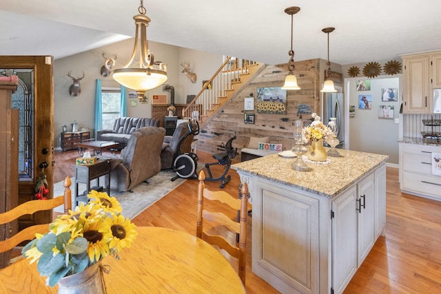 kitchen with light wood-type flooring, a center island, open floor plan, and freestanding refrigerator