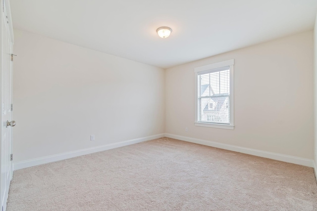 unfurnished room with baseboards and light colored carpet