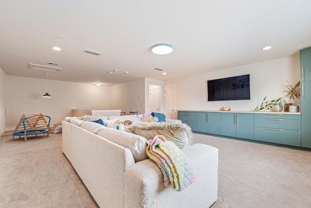 living area with recessed lighting, attic access, visible vents, and light colored carpet