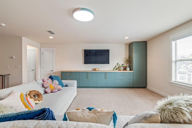 living room featuring recessed lighting, baseboards, visible vents, and light colored carpet