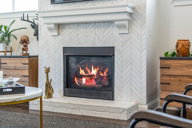 interior details featuring a warm lit fireplace and baseboards