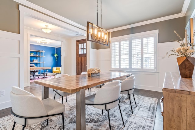 dining area with dark wood-type flooring, a chandelier, and crown molding