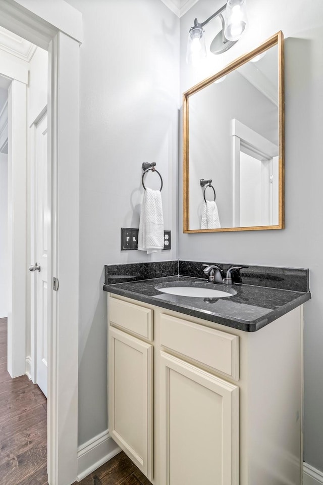 bathroom with wood finished floors, vanity, and baseboards