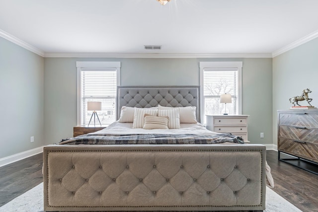 bedroom with baseboards, visible vents, dark wood finished floors, and ornamental molding