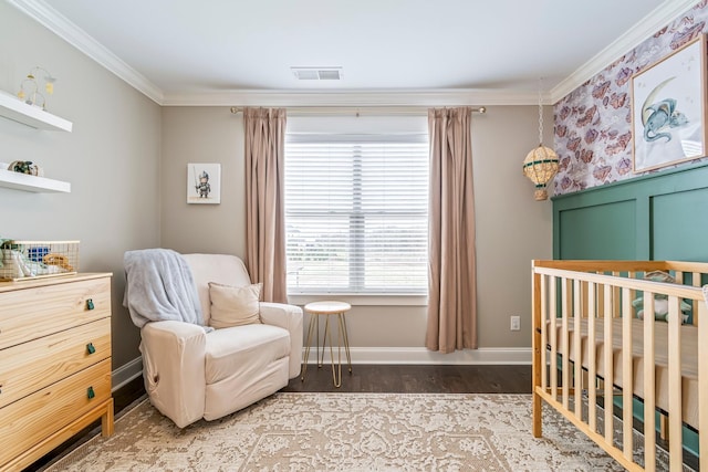 bedroom with a crib, baseboards, visible vents, crown molding, and light wood-style floors