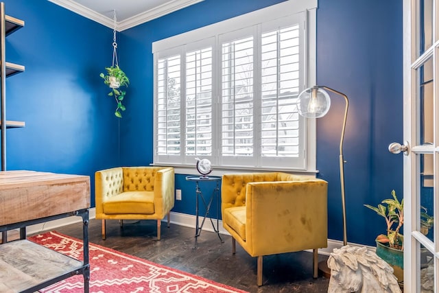 living area with ornamental molding, wood finished floors, and baseboards