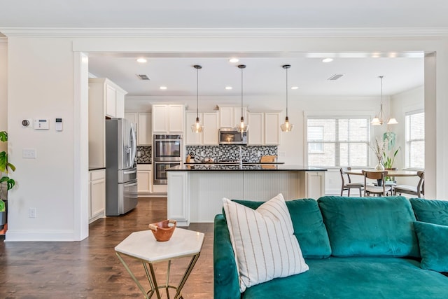 living area with visible vents, dark wood finished floors, and crown molding