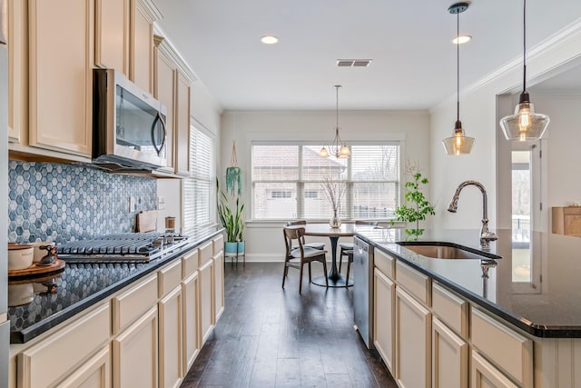 kitchen with stainless steel appliances, a sink, visible vents, backsplash, and dark wood-style floors