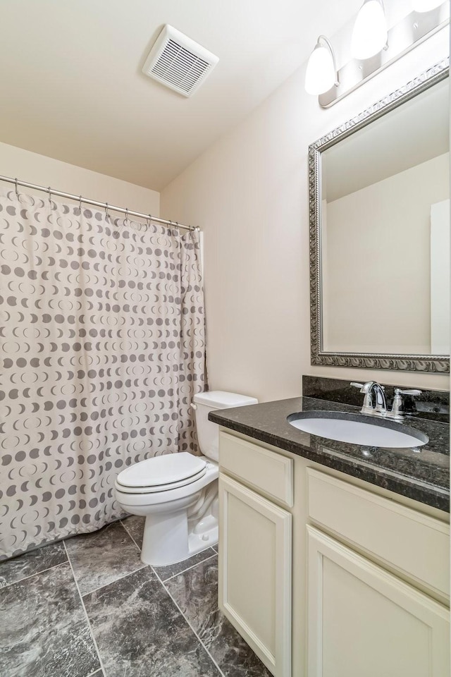 full bathroom with toilet, visible vents, and vanity