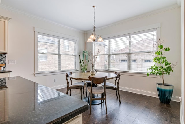 dining area with baseboards, dark wood-style flooring, crown molding, and a chandelier