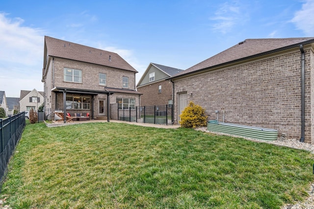 back of house with brick siding, a yard, a fenced backyard, and a patio