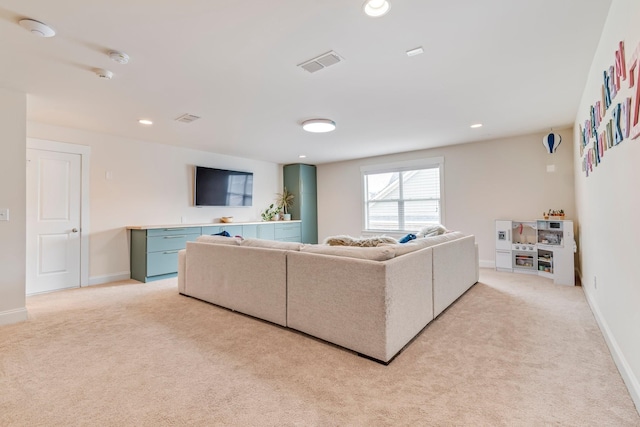 living room featuring light carpet, baseboards, and recessed lighting