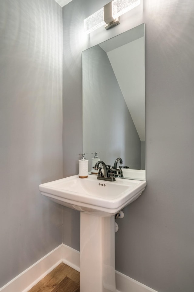 bathroom featuring a sink, wood finished floors, and baseboards