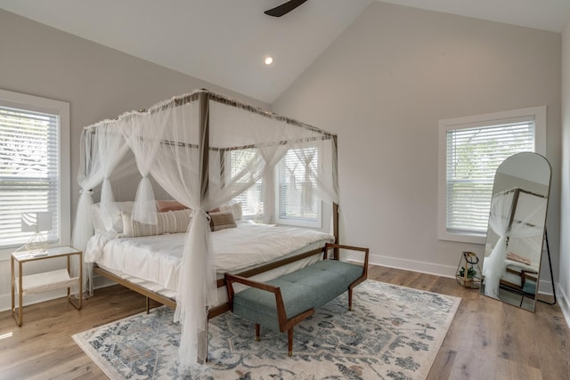 bedroom with high vaulted ceiling, recessed lighting, baseboards, and wood finished floors