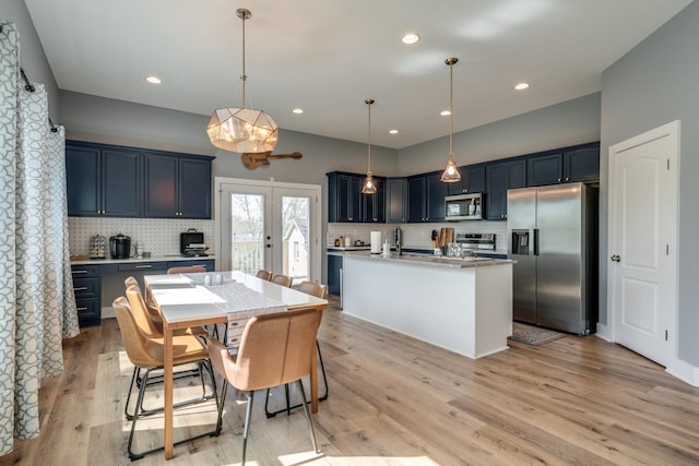 kitchen with french doors, appliances with stainless steel finishes, blue cabinetry, and light wood-style floors