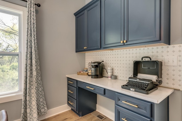 bar with light wood-type flooring, tasteful backsplash, visible vents, and baseboards