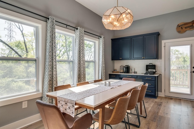 dining space with light wood-type flooring and baseboards