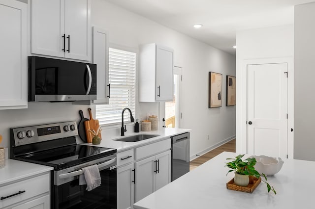 kitchen featuring stainless steel appliances, a sink, and light countertops