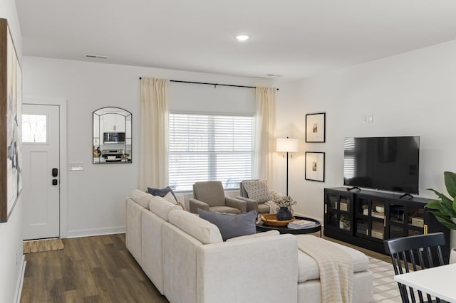 living area with dark wood-type flooring, recessed lighting, and baseboards