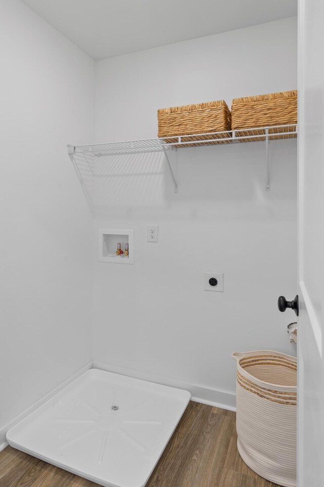 clothes washing area featuring hookup for an electric dryer, laundry area, washer hookup, wood finished floors, and baseboards