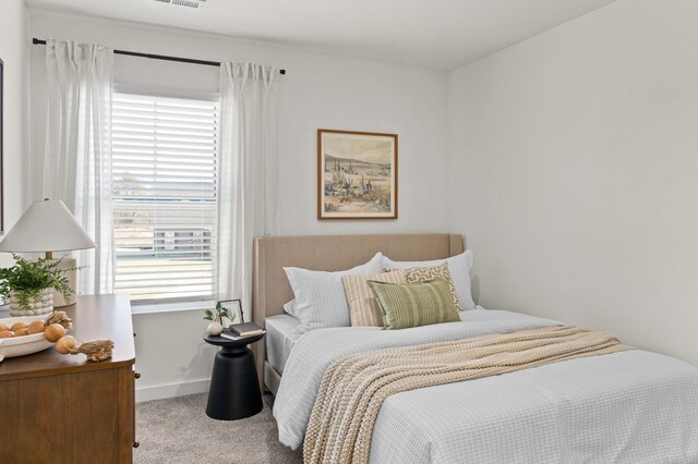 bedroom with carpet floors, visible vents, and baseboards