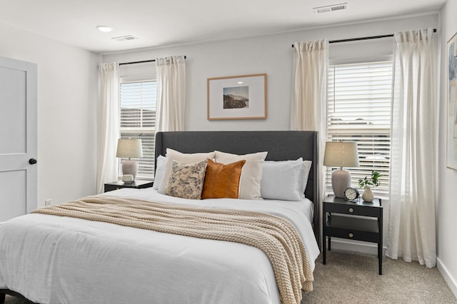 carpeted bedroom with visible vents and baseboards