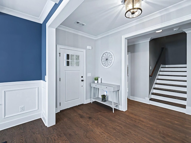 foyer featuring a wainscoted wall, wood finished floors, visible vents, stairway, and crown molding